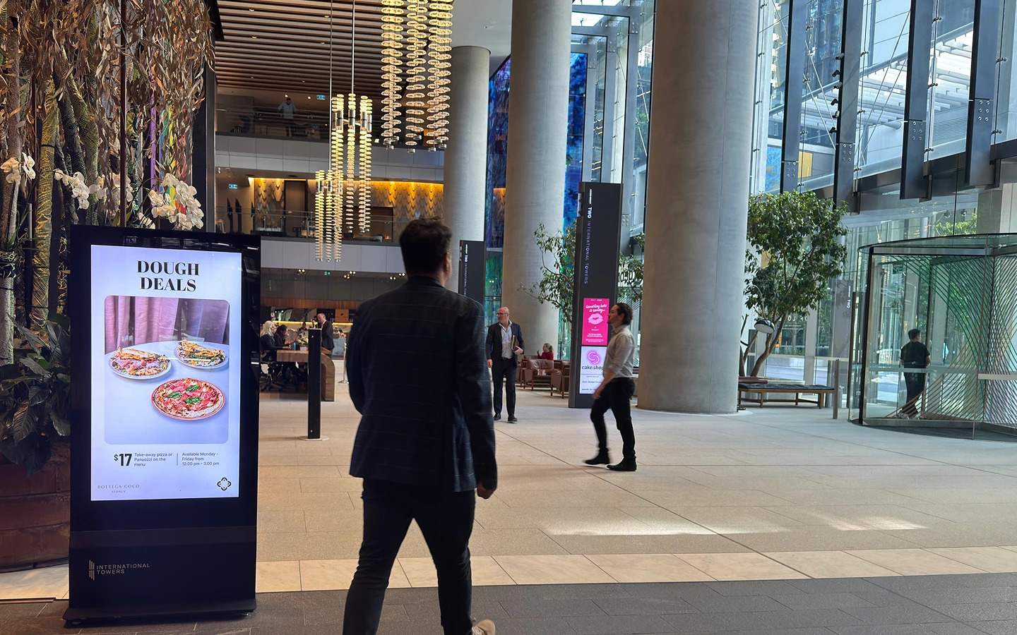 International Towers lobby with people and digital community screens